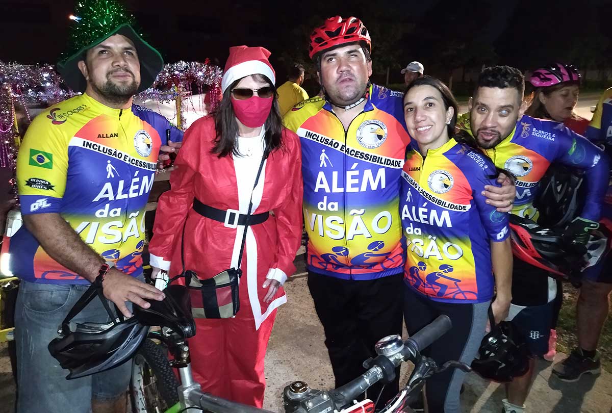Papai Noel de bicicleta levando o presente da inclusão